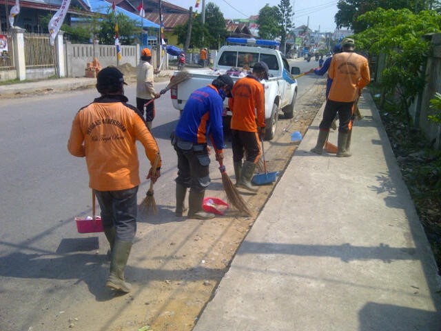 Petugas kebersihan membersihkan sampah usai pawai.