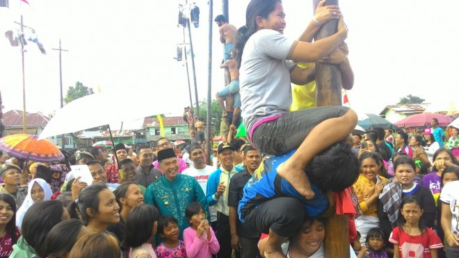 Walikota Jambi bersama warga sama-sama menyaksikan panjat pinang.