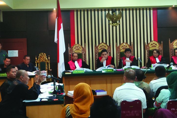 Jaksa memperlihatkan barang bukti berupa uang.
