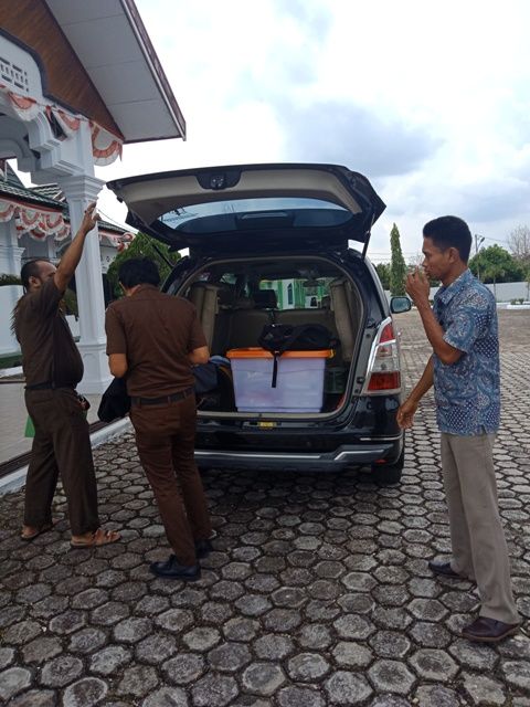 Terlihat Penyidik Kejati Jambi mengangkut satu kotak besar dokumen ke dalam mobil Innova berwarna hitam