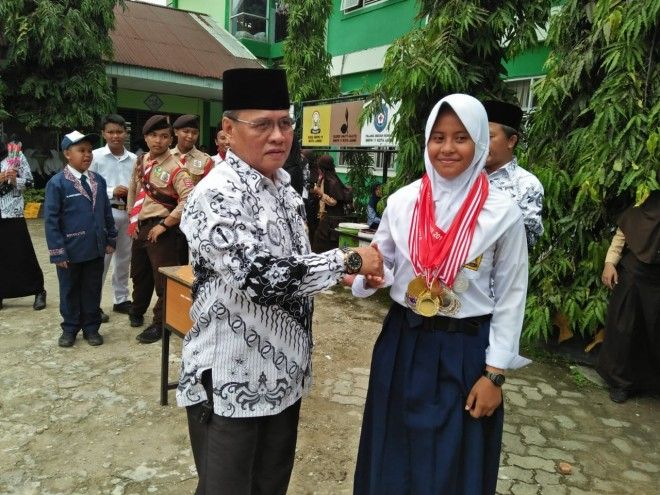 Kepala SMP 11 Kota Jambi Jamhuri Saat Memberikan Selamat Kepada Khalisah Ananda Merly, Siswa yang Berhasil Meraih Prestasi di Bilang Olahraga Panahan
