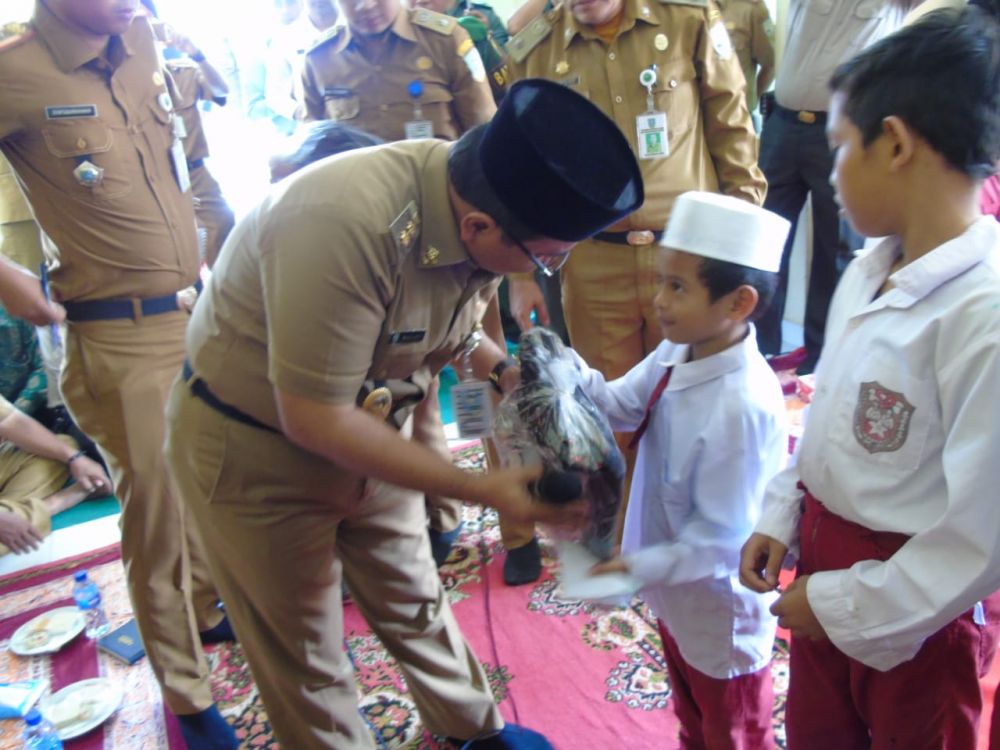 Maulana Menyerahkan Bantuan Ke Siswa SD