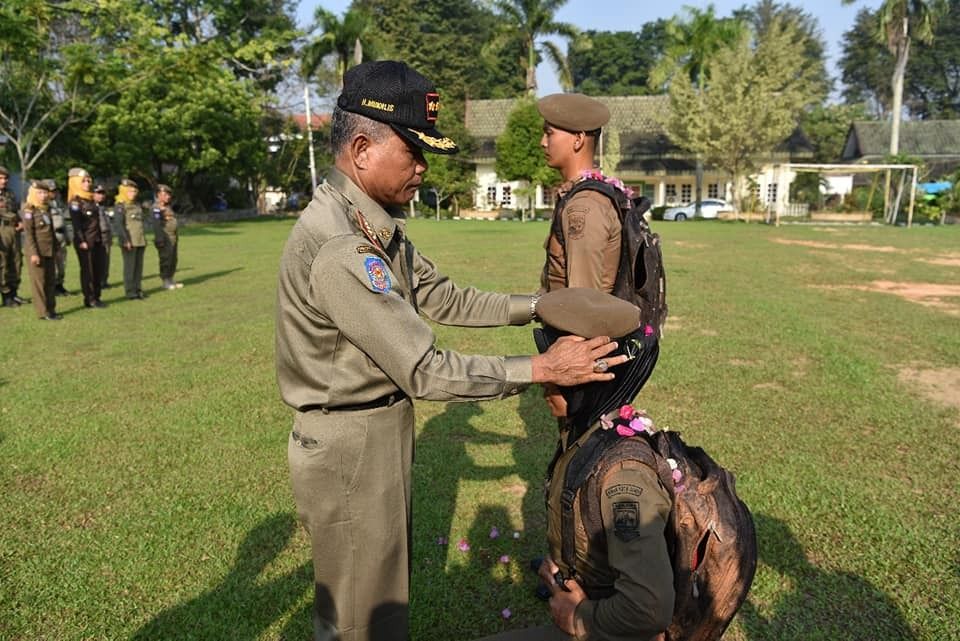 Asisten I Pemkot Jambi Mukhlis saat memasang baret bagi anggota Satpol PP yang mengikuti pelatihan, sabtu lalu