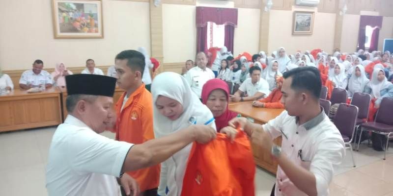 Sekda, H Thabroni Rozali Memasangkan Almamater Kepada Mahasiswi yang PKN di Sarolangun