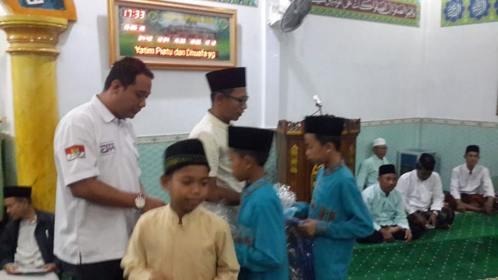 Perwakilan WOM memberikan santunan pada anak yatim