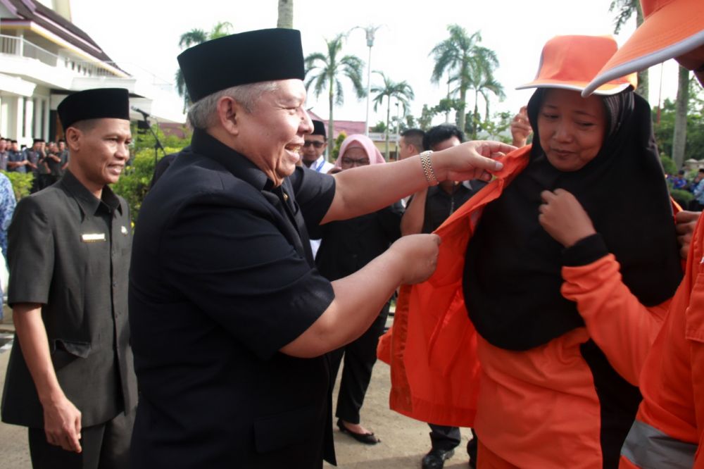 Bupati Safrial memasang jaket ke petugas pada peringatan hari lingkungan hidup.jpg