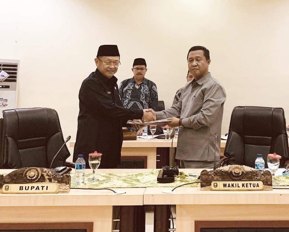 Pimpinan sidang paripurna H Hapis Hasbiallah menyerahkan dokumen pandangan umum fraksi kepada Bupati, H Cek Endra
