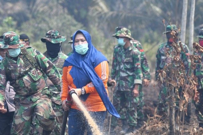 Bupati Muaro Jambi Masnah Busro saat ikut memadamkan kebakaran lahan di Kecamatan Kumpeh Ulu.