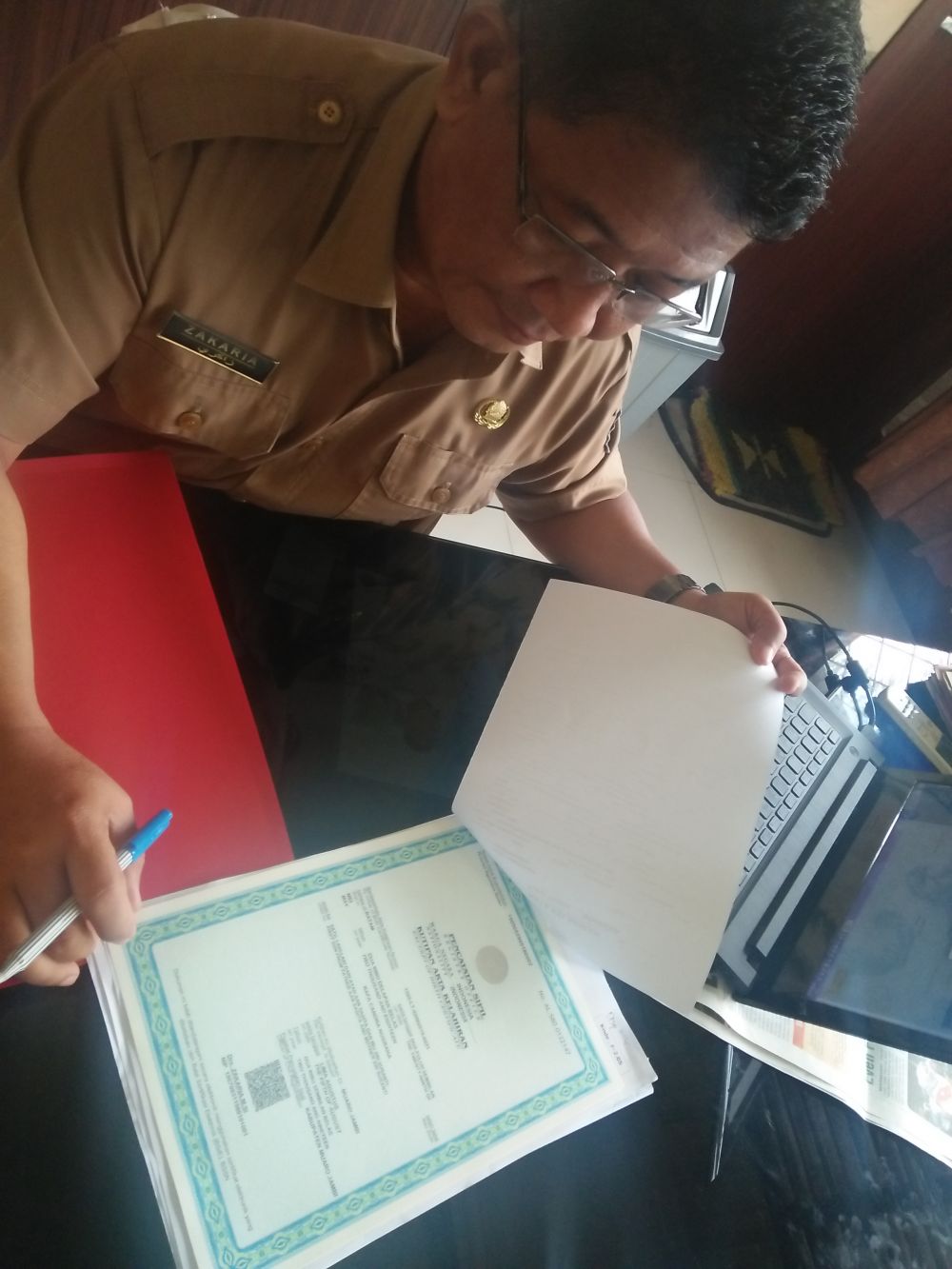 Kepala Dinas Dukcapil Muarojambi memperlihatkan Barkot atau tanda tangan elektronik pada Kartu Keluarga.