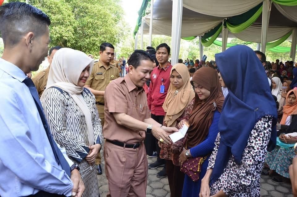 Bupati menyerahkan buku tabungan PKH.