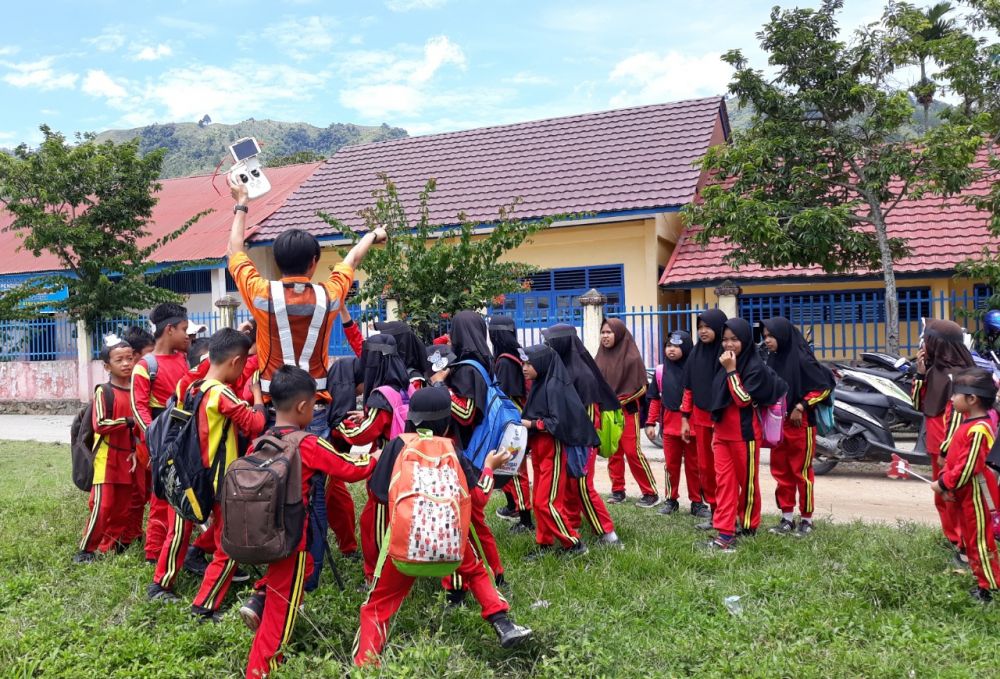 Daniel Supit, seorang insinyur geodesi diserbu oleh anak-anak yang tertarik untuk merasakan pengalaman mengoperasikan drone (foto : Deki Permana
