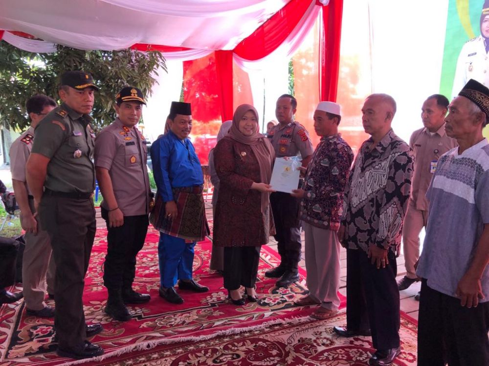 Bupati menyerahkan sertifikat.