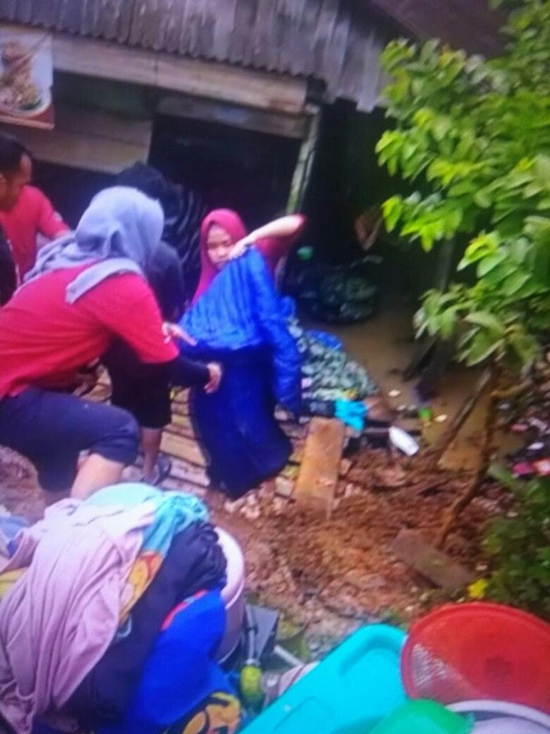 Warga memindahkan pakaian serta peralatan rumah tangga yang basah 