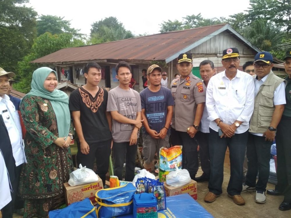 Bupati foto bersama warga usai menyerahkan bantuan.