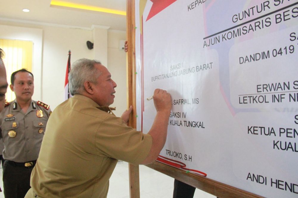 Safrial membubuhkan tanda Tangan.