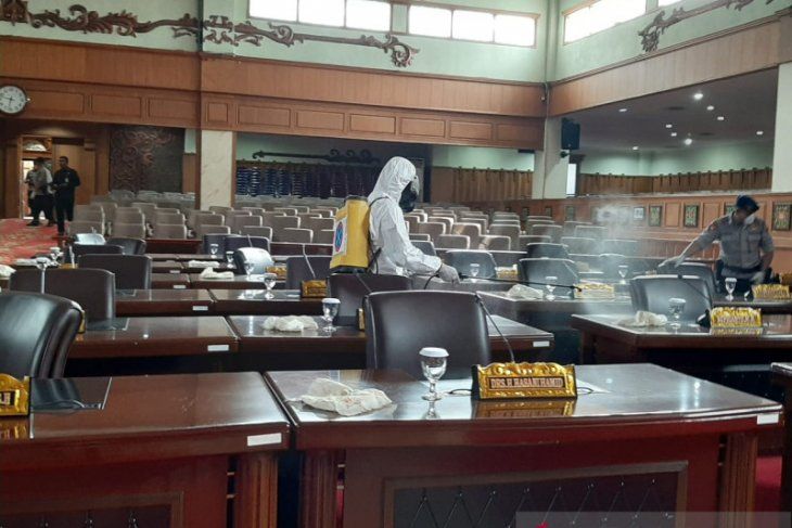 Personel Gegana Brimob Polda Jambi menyemprot cairan disinfeksi di ruang paripurna DPRD Provinsi Jambi, Rabu (18/3). 