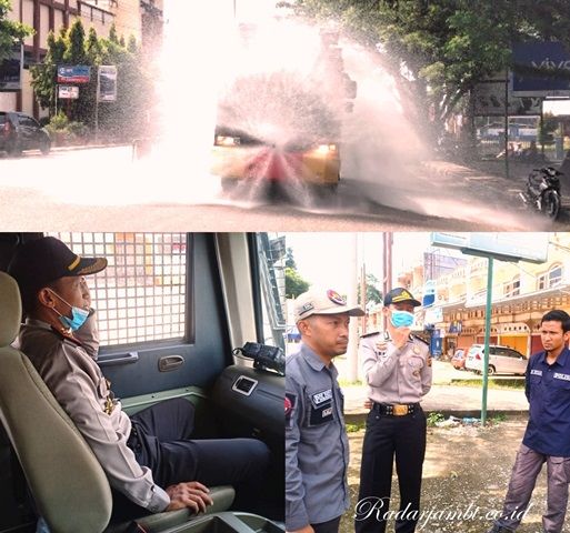 Kapolres Sarolangun, AKBP Deny Heryanto pimpin kegiatan penyemprotan Jalan Lintas Sumatera wilayah Pasar Saroangun dengan menerjunkan Water Canon  