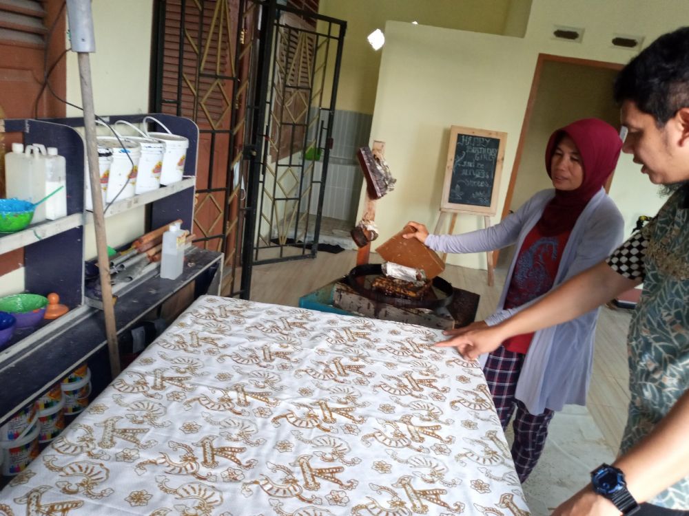 Legal and Relation Assistant Manager Jambi Field, Ari Rachmadi dan Ketua Kelompok Batik Serumpun Berlian, Tinah berbincang terkait motif batik.