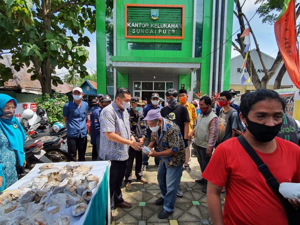 Anggota DPRD Kota Jambi Kemas Faried Alfarelly saat membagi makan gratis di depan kantor kelurahan sungai putri 