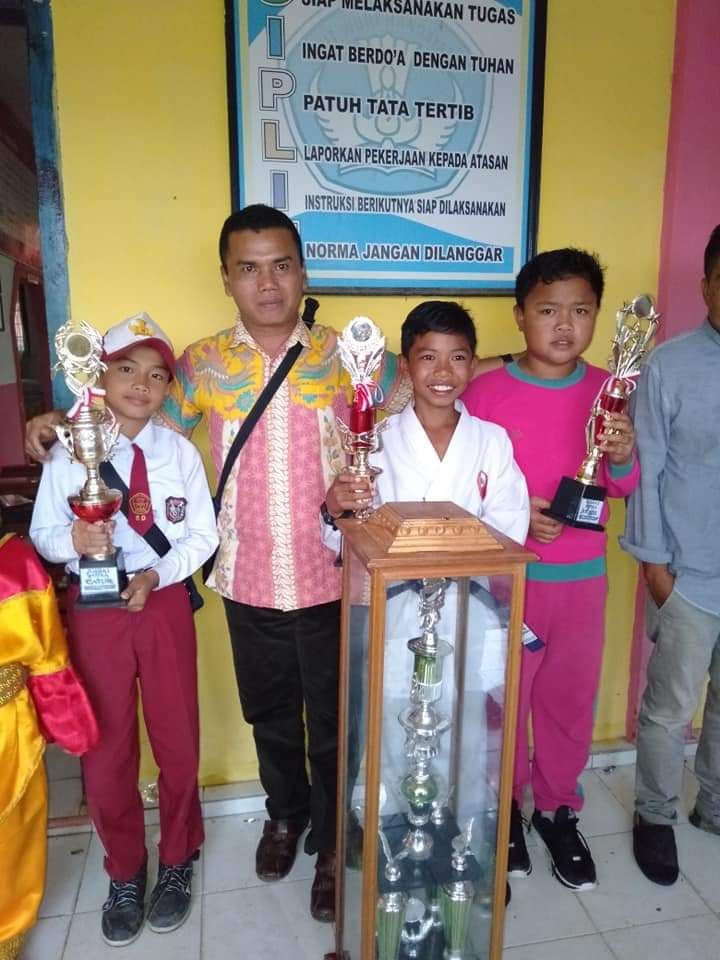 Kepala SDN 173/III, Adriadi, S.Pd dan siswanya saat berfoto bersama usai meraih Juara Umum KSN, KOSN, dan FLS2n Tingkat Ke. Keliling Danau