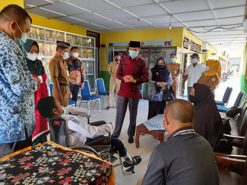 Ketua DPRD Provinsi Jambi Edi Purwanto menyerahkan bantuan kursi roda kepada Anugrah Alfitrah, siswa kelas 7 SMP Negeri 6 Kota Jambi, Senin (19/4/2021). 