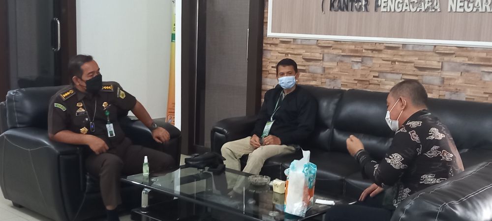Subhi (memakai jaket hitam ) saat menyerahkan diri ke Kejari Jambi, Selasa (3/8)