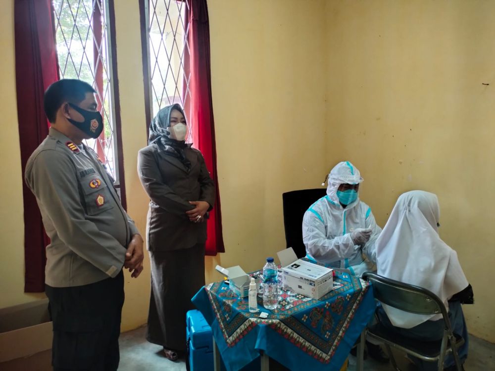 Kepsek SMKN 5 Tebo mendampingi Kapolsek Rimbo Ilir AKP Ibrahim mengecek pelaksanaan vaksinasi.