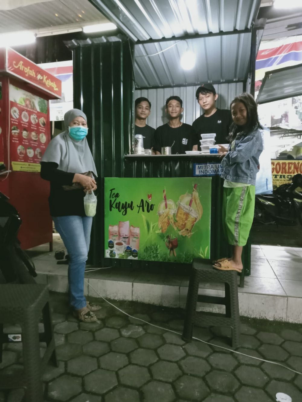 Anak panti asuhan tengah melayani pembeli teh kayu aro
