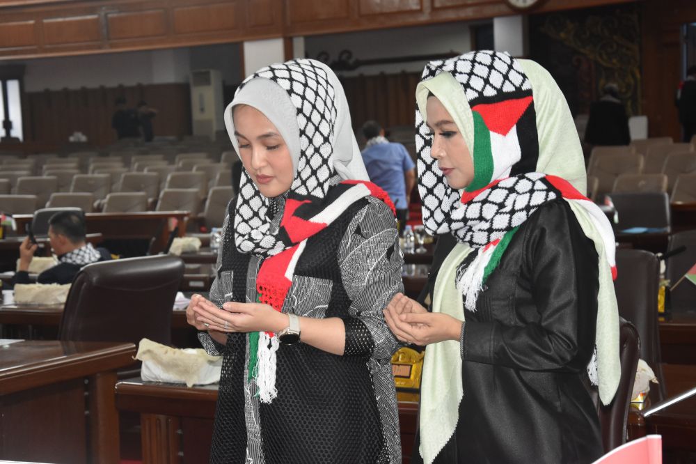 Dua anggota DPRD Provinsi Jambi, Eka Marlina dan Ezzaty tengah mengaminkan seruan doa untuk Palestina sebelum rapat paripurna DPRD Provinsi Jambi, Senin (5/11).